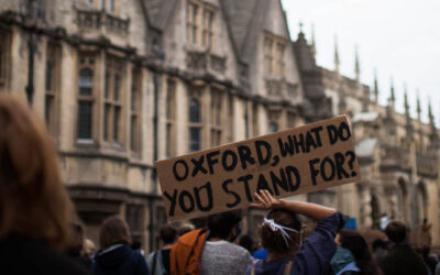 Oxford BLM Protest Image featuring a person holding a sign that reads 'Oxford, What do you stand for?' by Emily Jarrett Photography