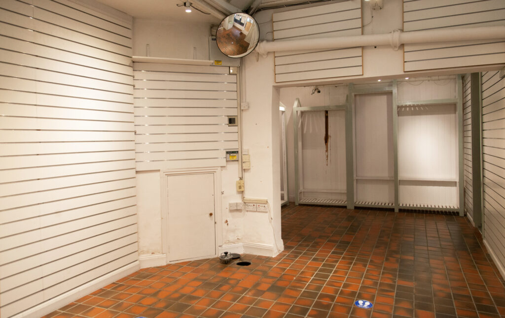 Photograph of The Covered Market Unit Empty, with White Walls and Red Tile Floors