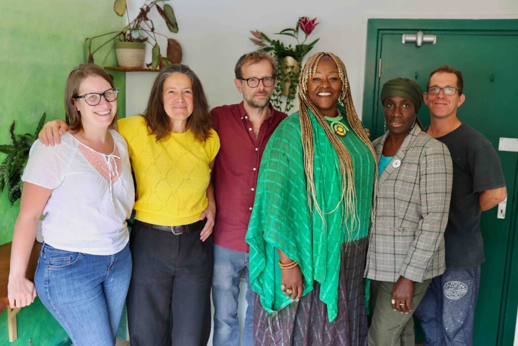 A group of people stand in the Owned By Oxford Oasis smiling to camera