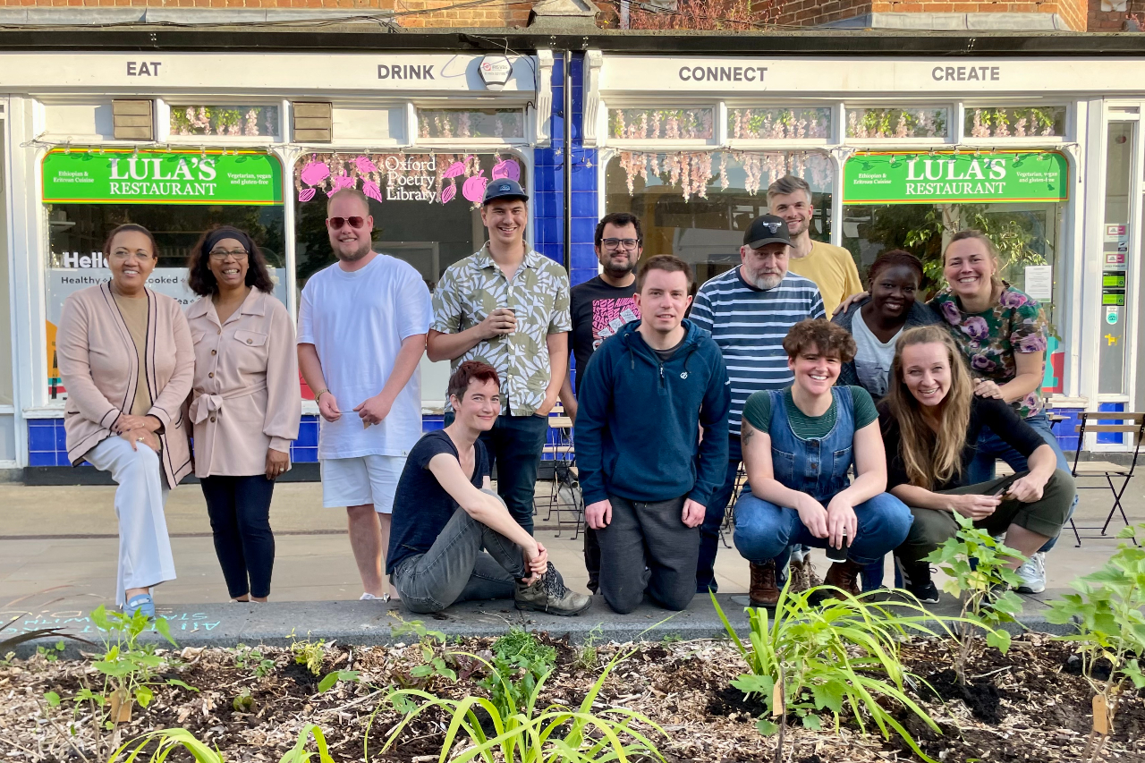 CAB Photos 06.2400079 A group of people pose in front of a newly planted garden bed