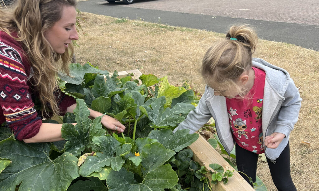 A woman and a child tending to a raised bed