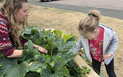 A woman and a child tending to a raised bed