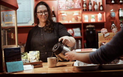 Micaela Tuckwell working behind the bar in the UPP, pouring coffee for an unseen guest